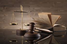 balança da justiça martelo de juiz livro de direito em tons marrom sobre uma mesa