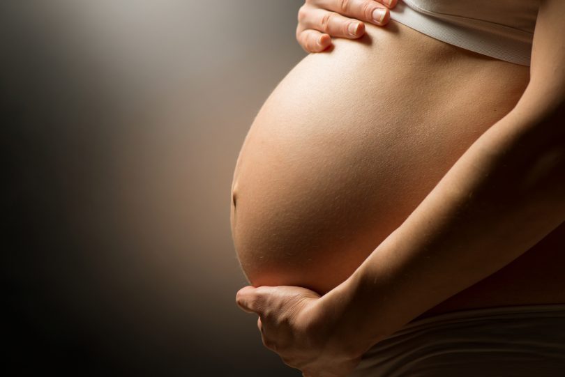 mulher grávida acariciando barriga