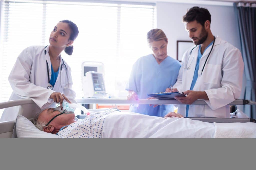 equipe médica em sala de operação com paciente deitado em maca